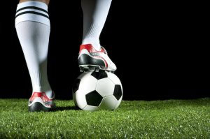 Man with one foot on a soccer ball