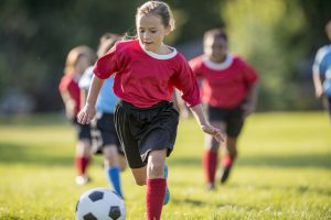 Girl Kicks Ball Up Field